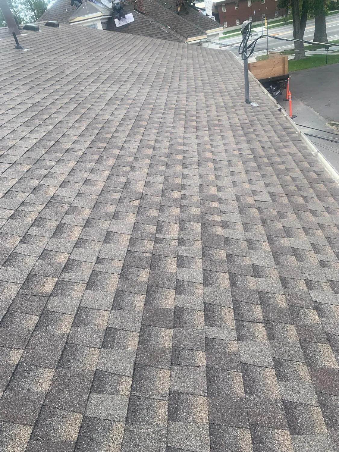 Freshly laid architectural asphalt shingles running in clean courses