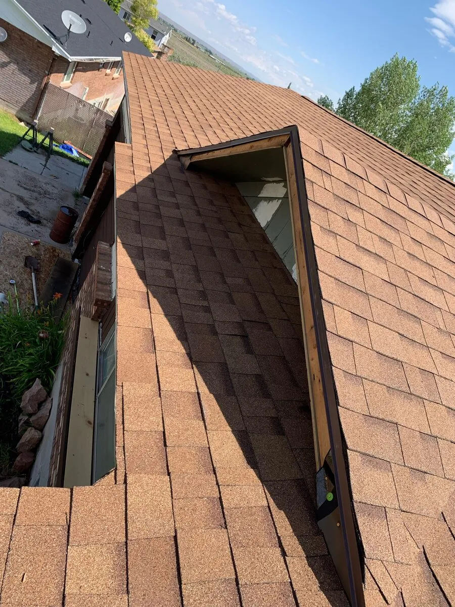 Dormer wrapped tight to the valley on a completed asphalt roof